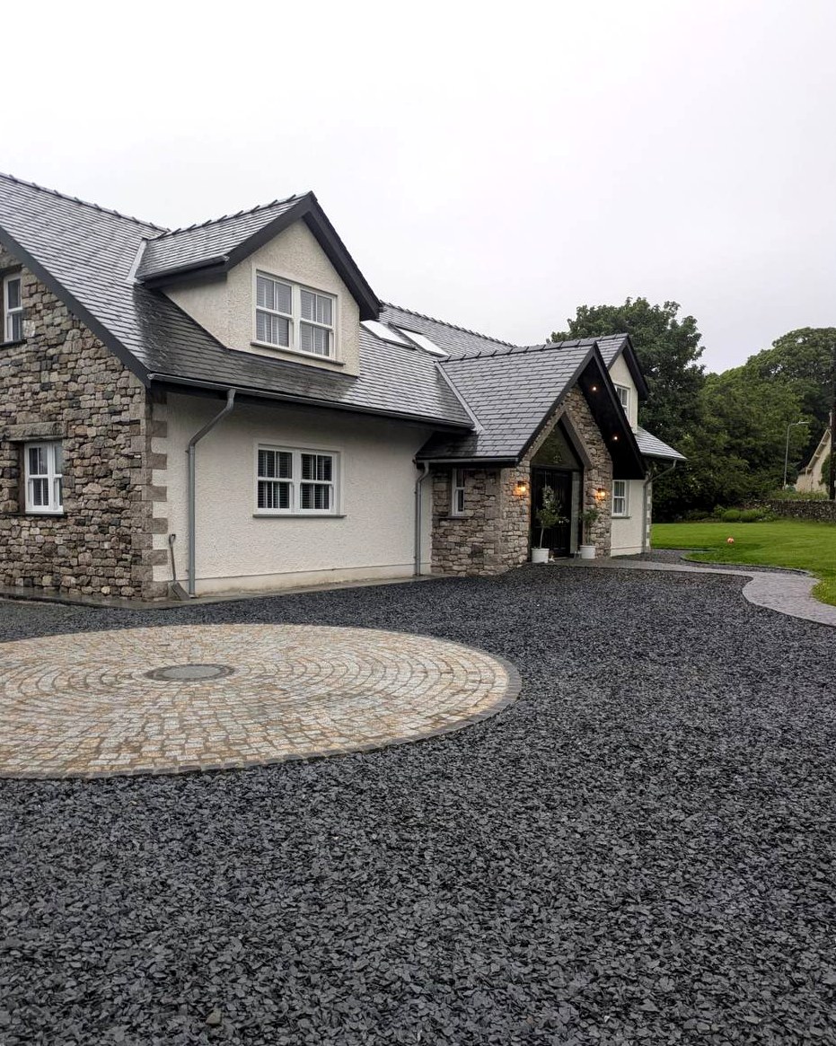 Large property with natural stonework, entrance detailing, gravel driveway and circular paved feature by Sam Shaw Kilburn Stonework Ltd