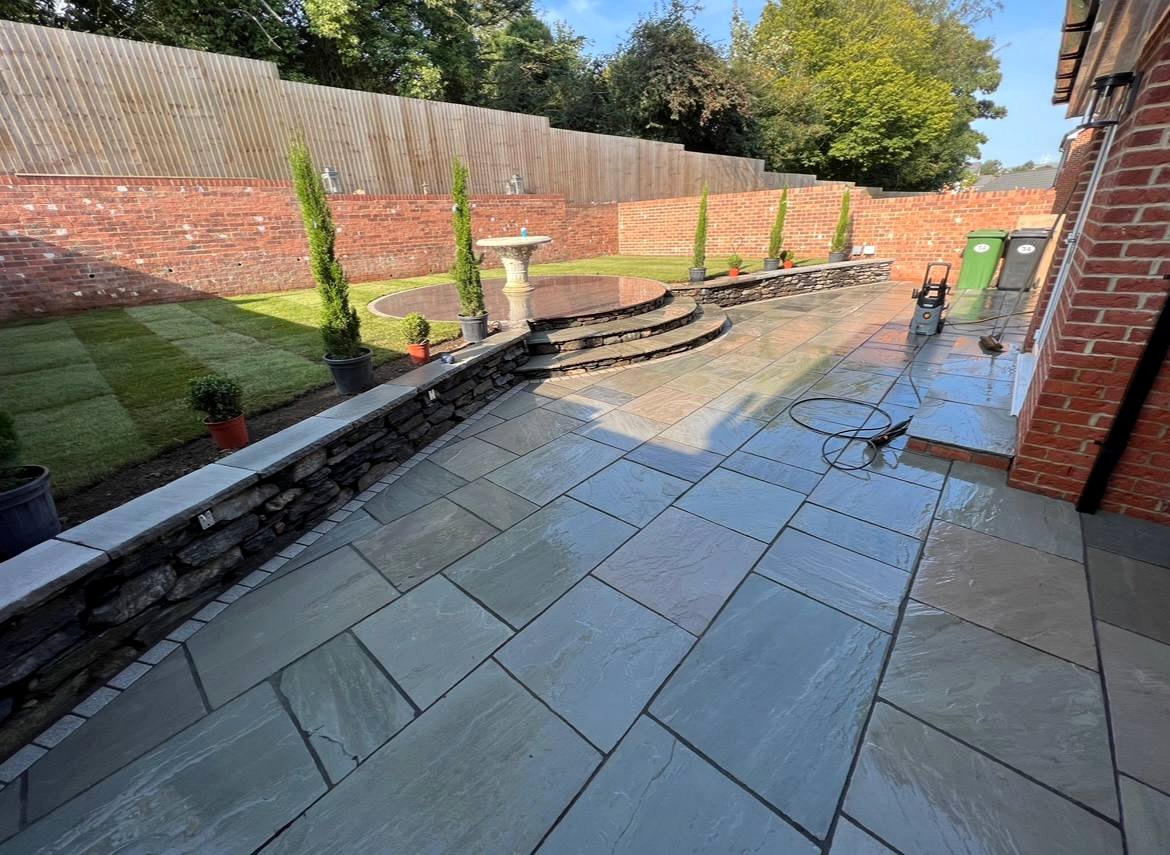Wide patio with curved stone steps and retaining wall