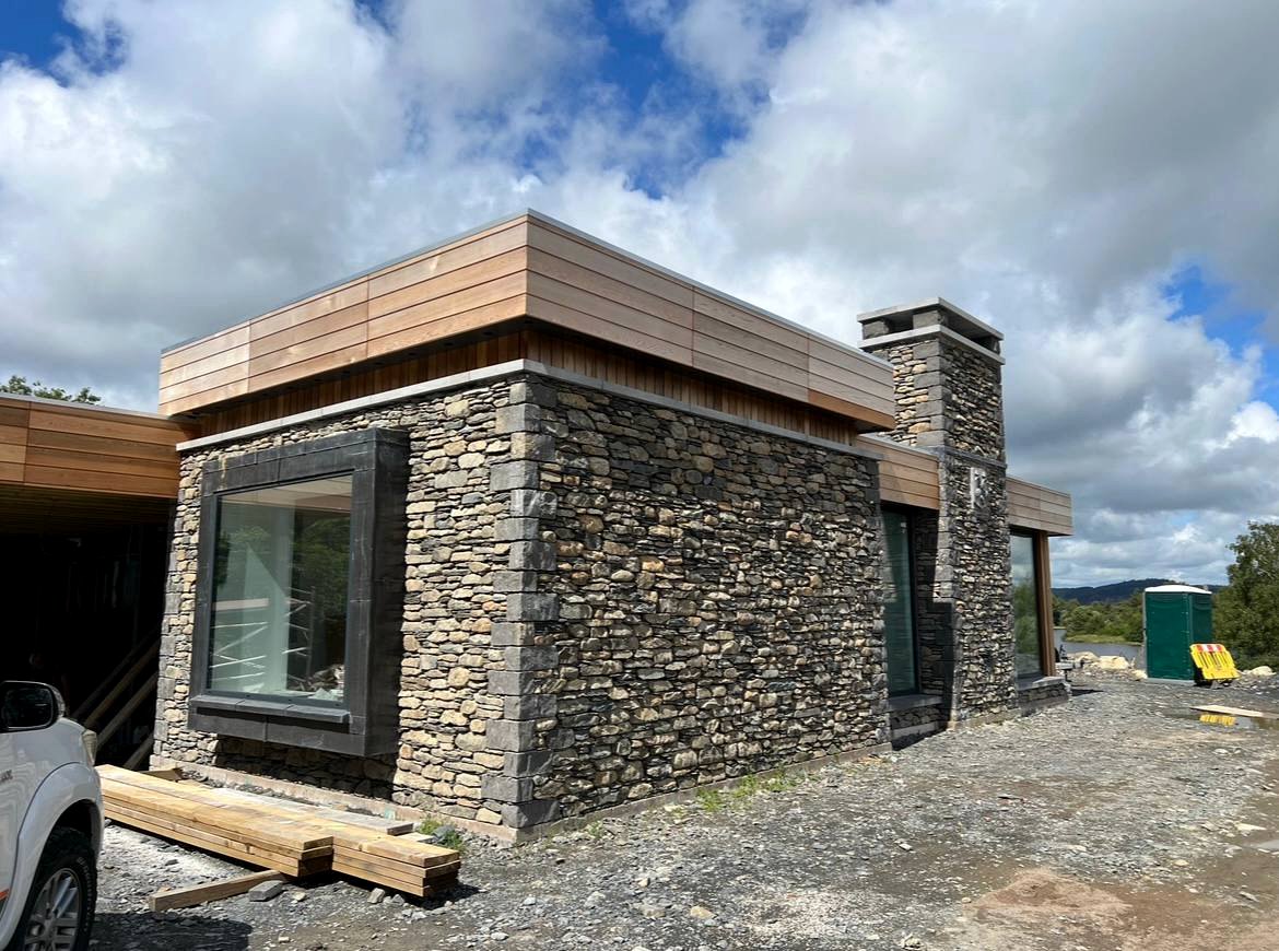 Modern property with natural stone facing and feature chimney by Sam Shaw Kilburn Stonework Ltd