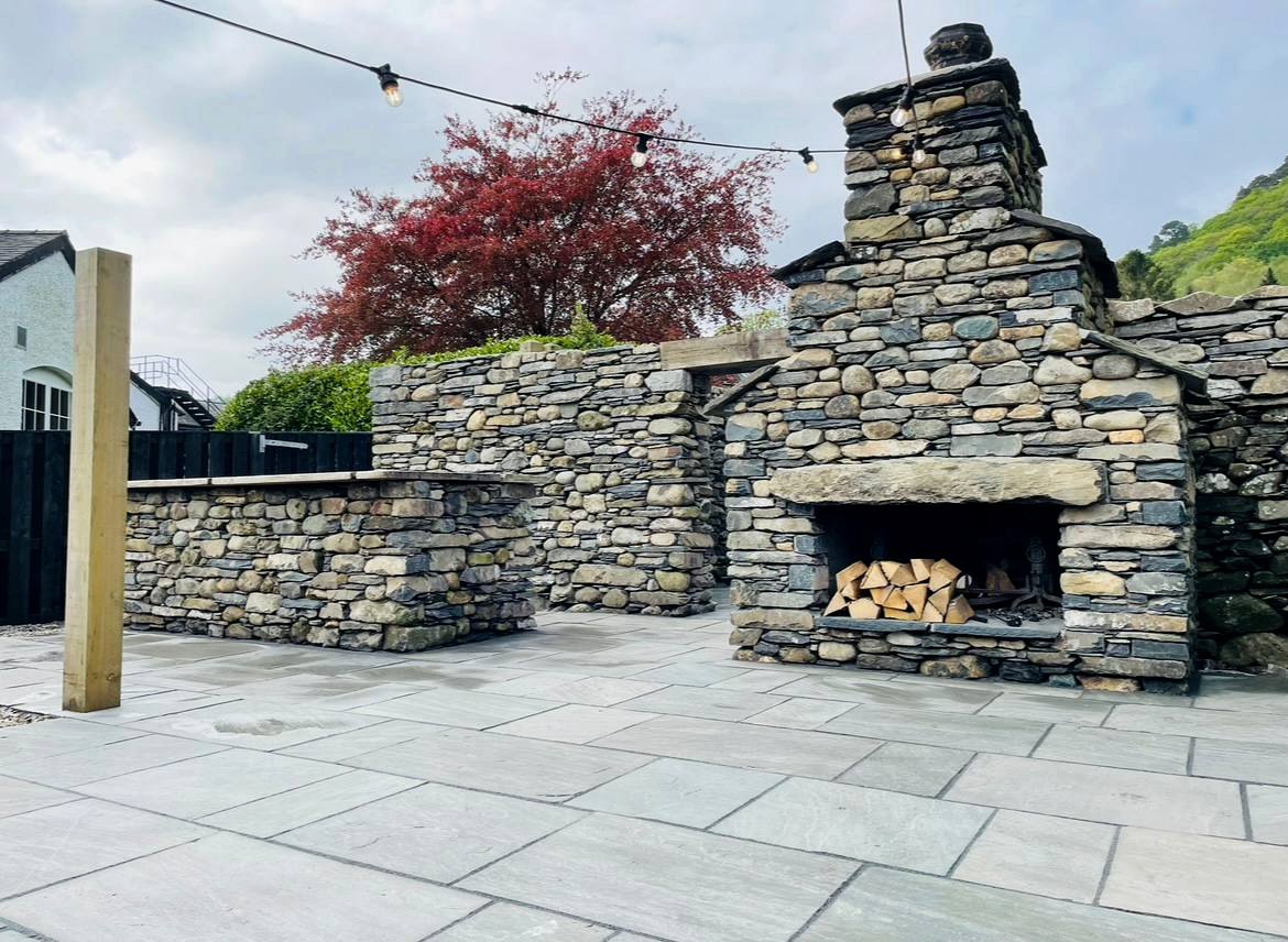 Evening lit natural stone wall and patio paving